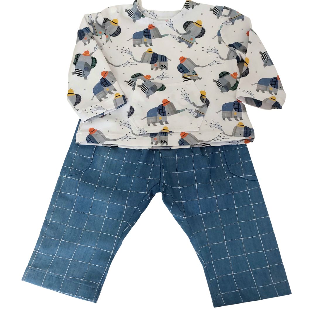 Conjunto de bebé, compuesto por una camisa de estampado de elefantes bomberos sobre fondo blanco con un bolsillito en la barriga y suave pantalón azul imitación denim con sus bolsillos